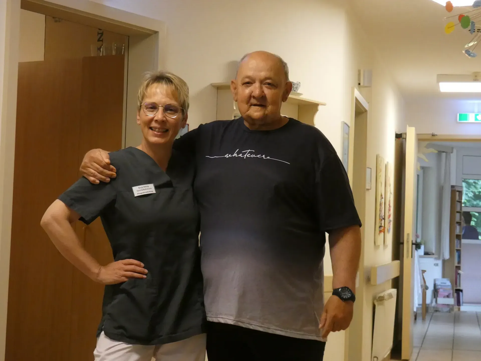 Ein Mann und eine Frau posieren in einem Flur für ein Foto.