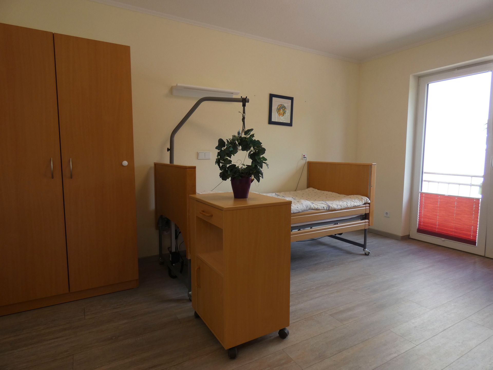 Ein Krankenhauszimmer mit einem Bett und einem Nachttisch.