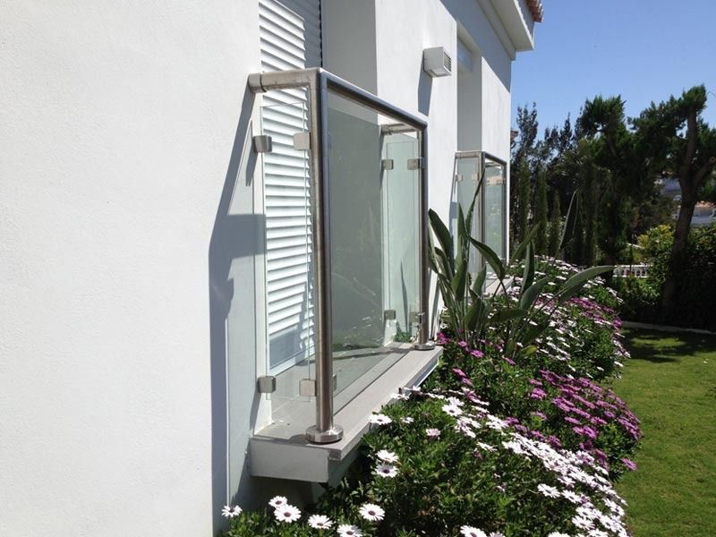 Una casa blanca con un balcón y flores delante.