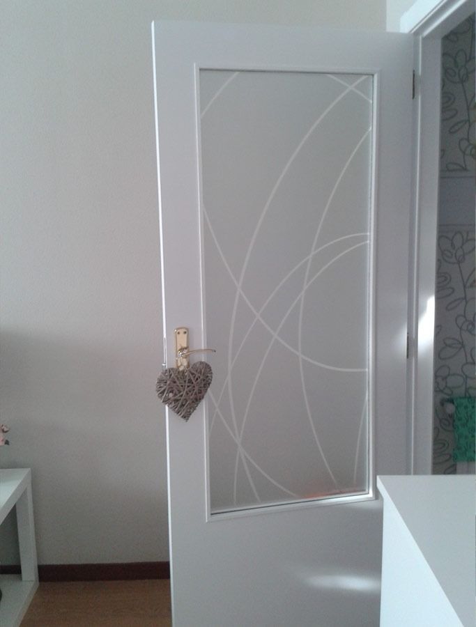Una puerta blanca con un corazón colgando en una habitación.