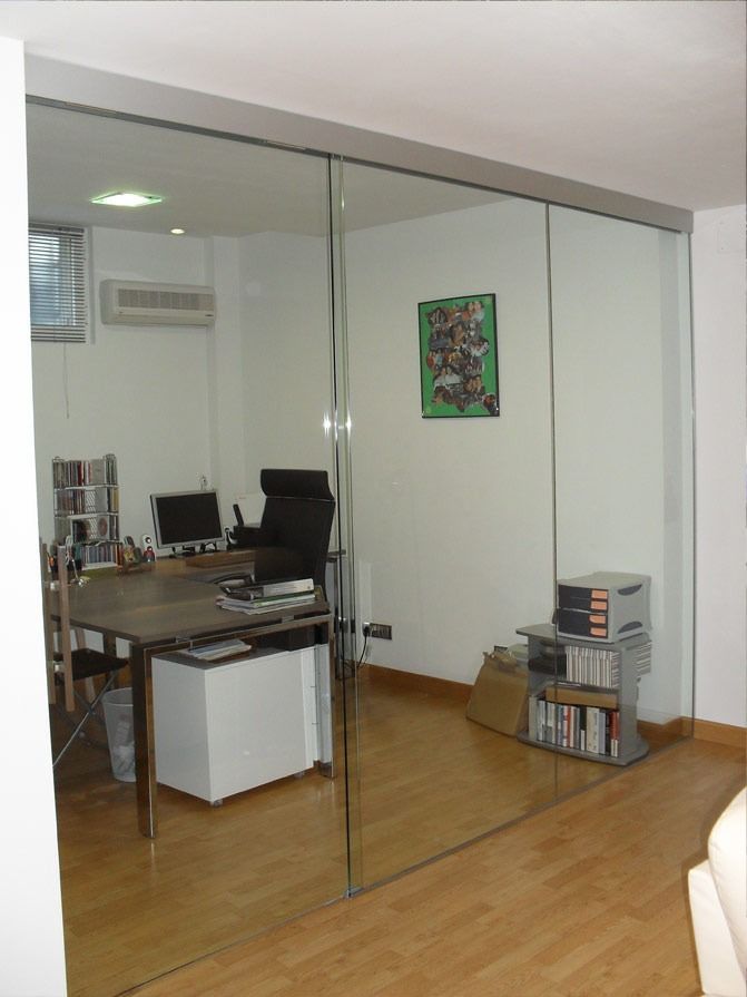 Una habitación con un escritorio y sillas y un cuadro en la pared.