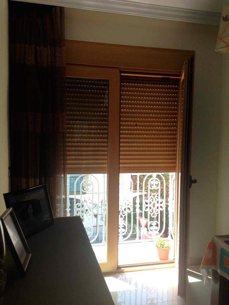 Una habitación con una puerta corrediza de vidrio y persianas.