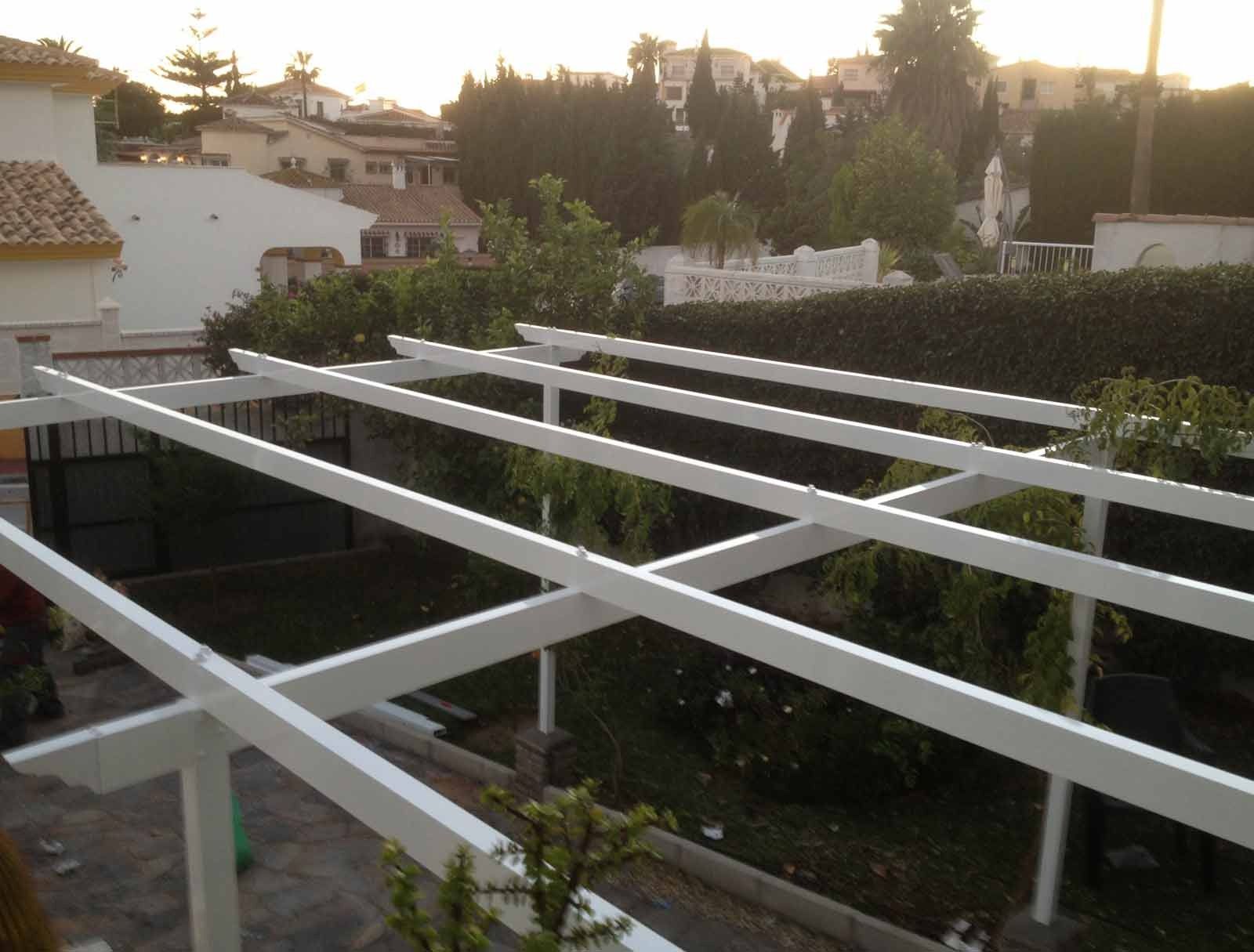 Se está construyendo una pérgola blanca en un patio trasero.