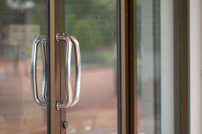 Un primer plano de una puerta corrediza de vidrio con manija.