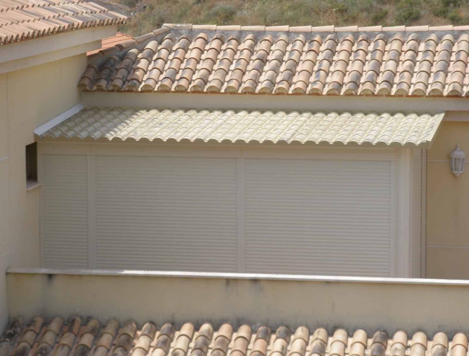 Un edificio blanco con techo de tejas y una ventana.