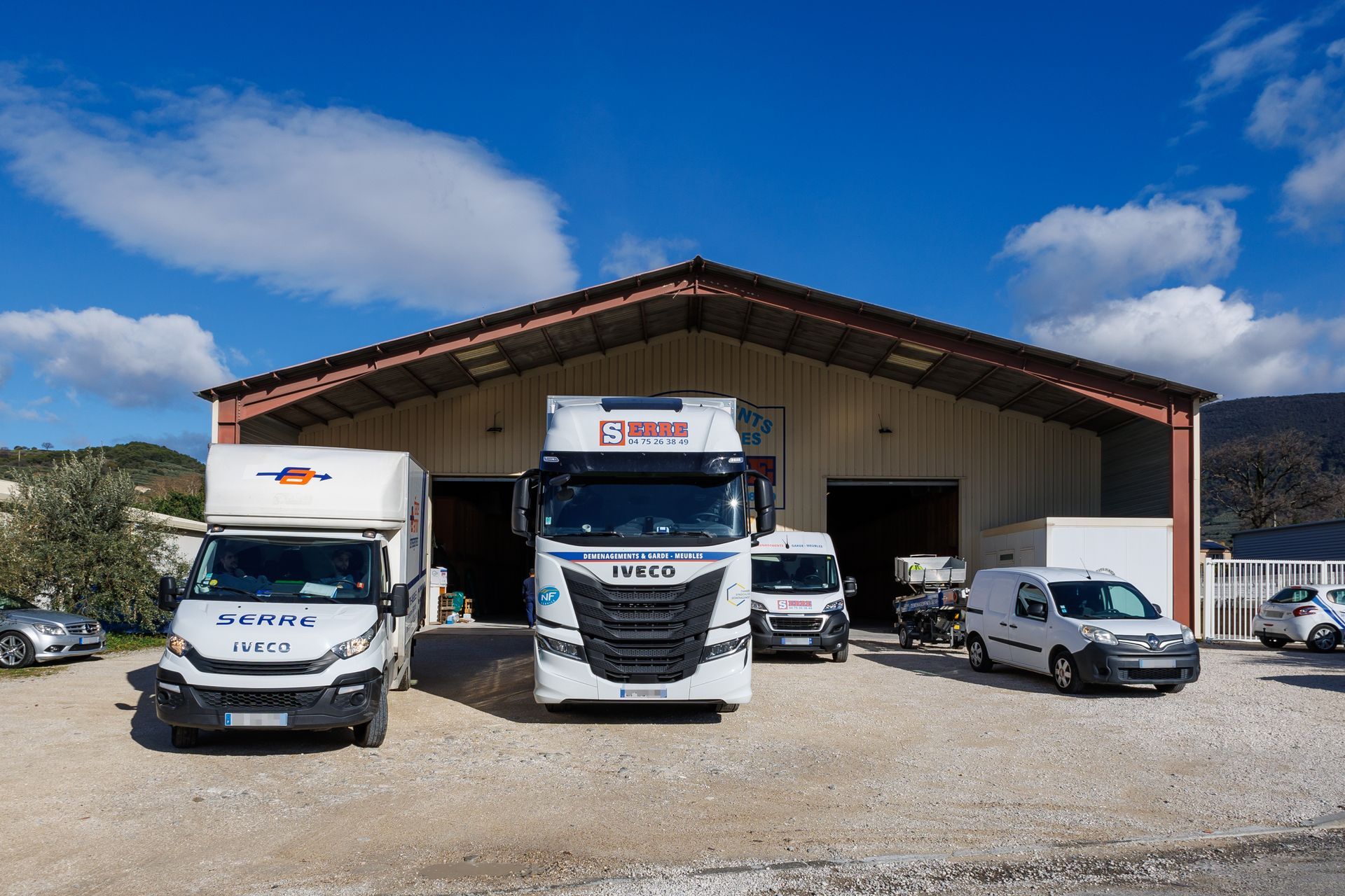 Plusieurs véhicules de l'entreprise Déménagements Serre devant leur entrepôt