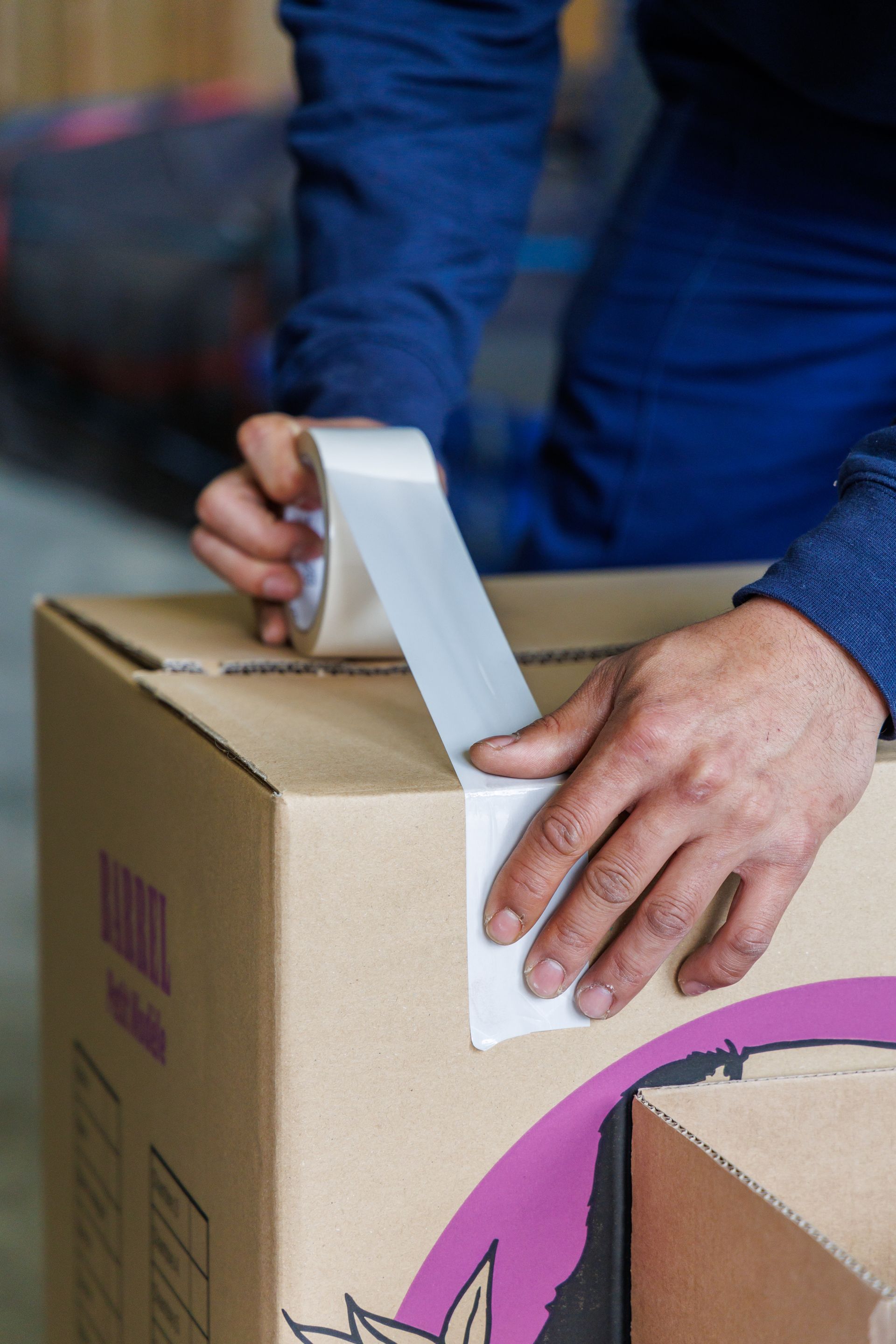 Mains d'un professionnel fermant un carton