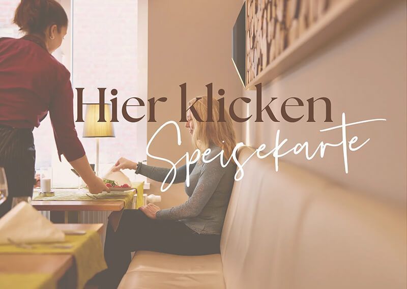 Eine Kellnerin bedient eine Frau an einem Tisch in einem Restaurant.