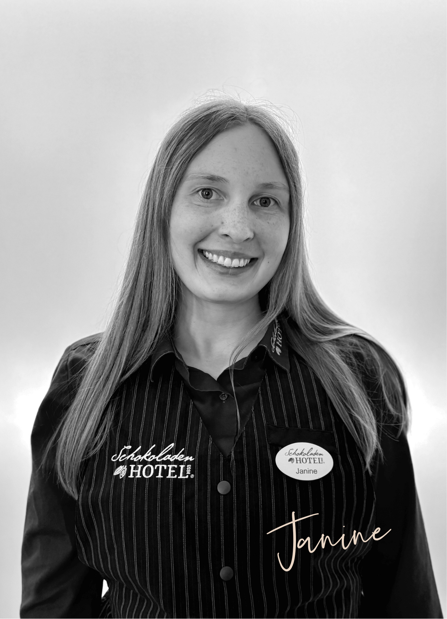 Janine aus dem Team Service mit einem breiten Lächeln. Schwarz-weißes Foto.