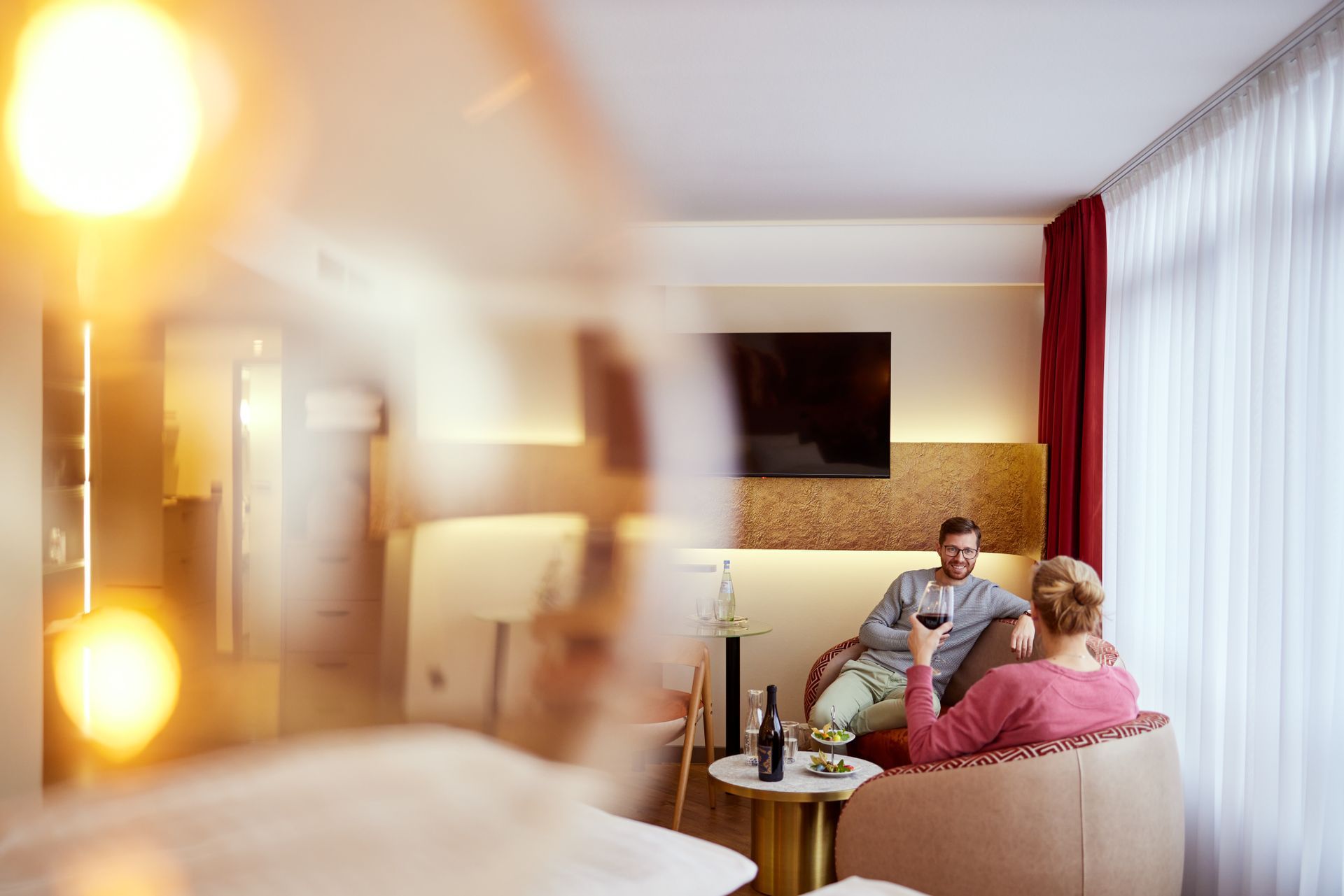 Ein Mann und eine Frau sitzen auf einer Couch in einem Hotel.