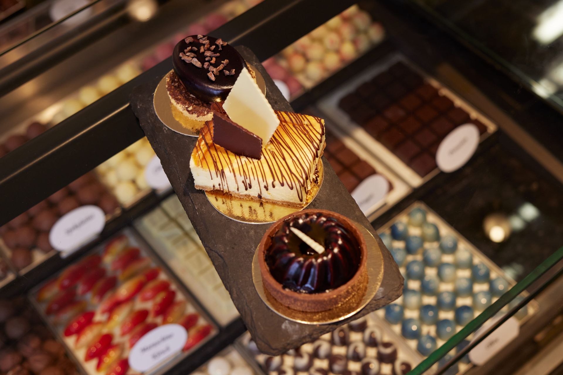 In einer Glasvitrine werden verschiedene Desserts präsentiert.