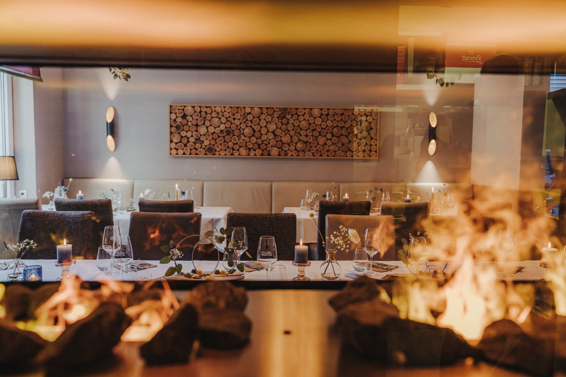 Ein Restaurant mit Tischen und Stühlen und einem Kamin in der Mitte des Raumes.