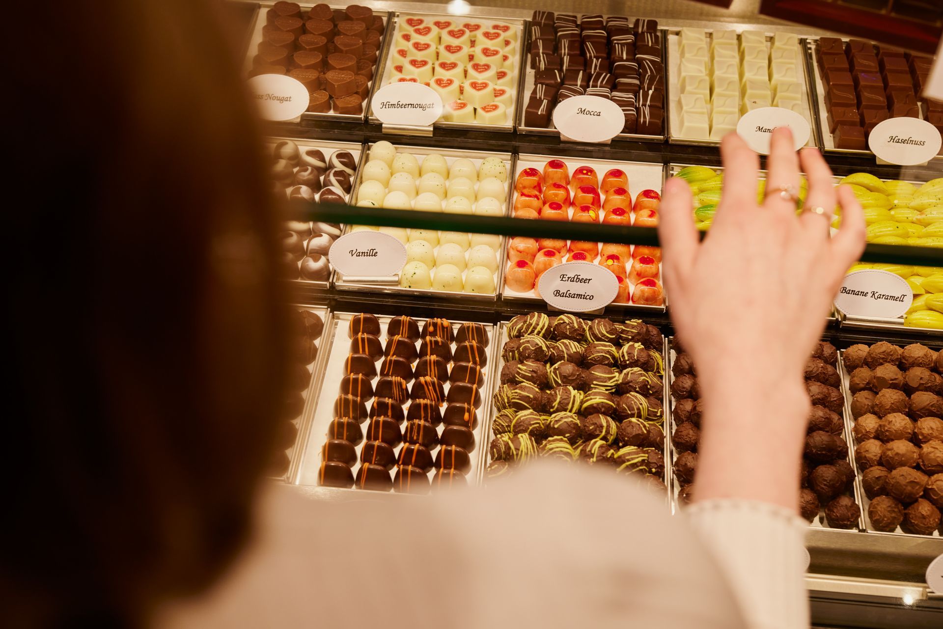 Eine Frau schaut sich im Schokoladenhotel eine Auslage mit Pralinen an.