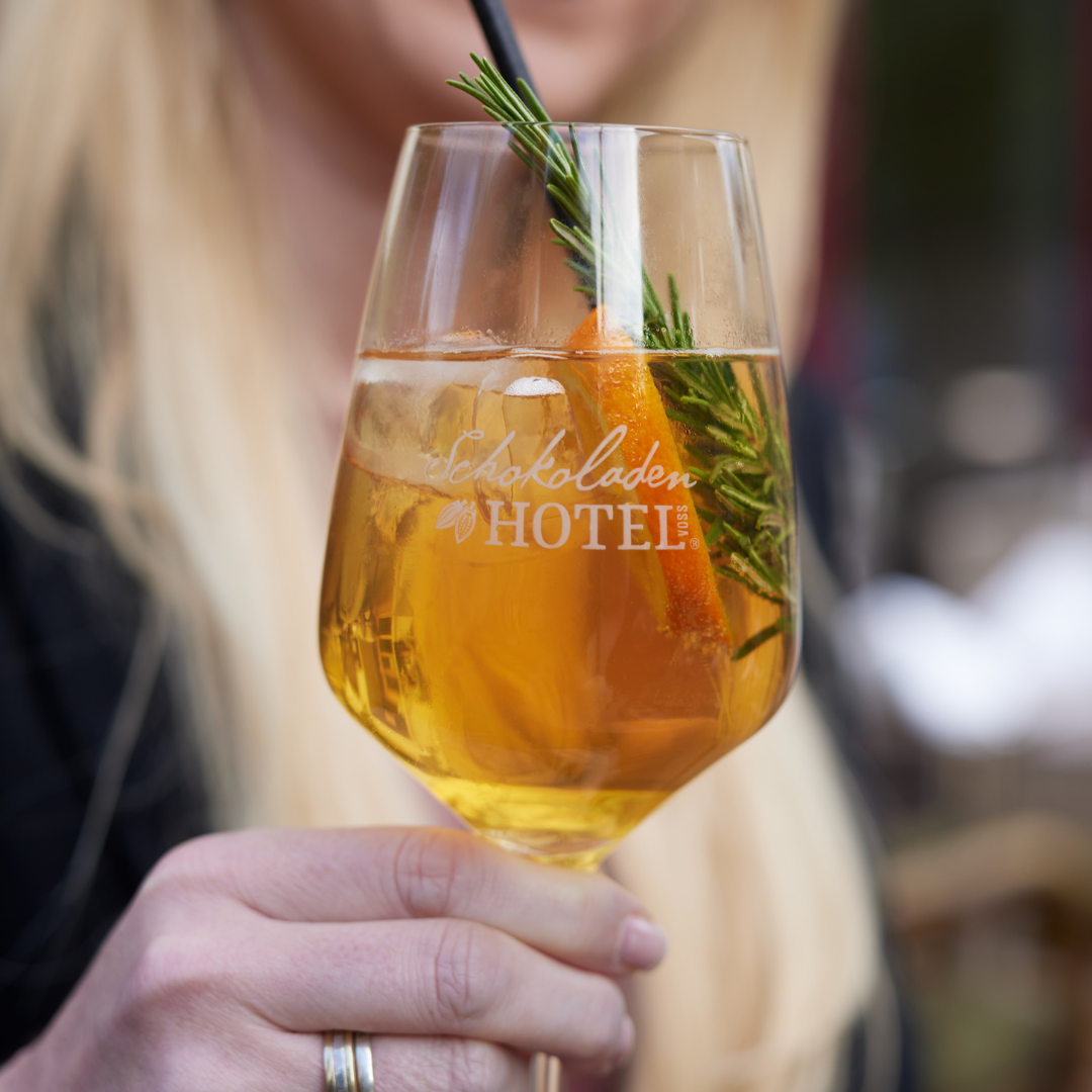 Eine Frau hält ein Glas mit der Aufschrift „Schokoladen Hotel“ darauf