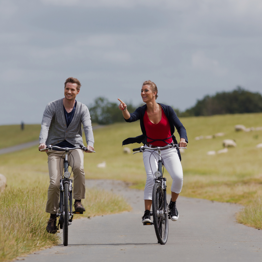 Ein Mann und eine Frau fahren mit dem Fahrrad einen Weg entlang