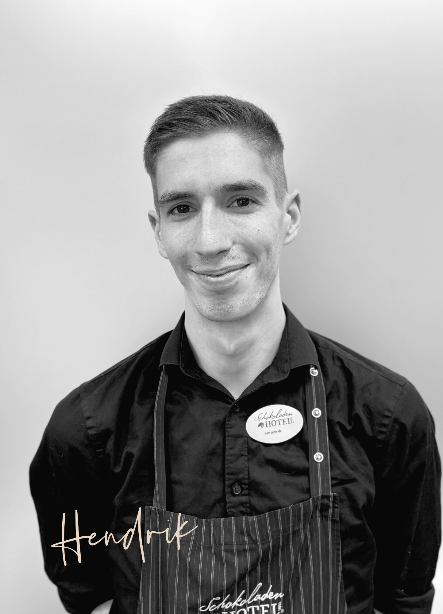 Hendrik aus dem Serviceteam mit einem freundlichen Lächeln. Schwarz-weißes Bild.