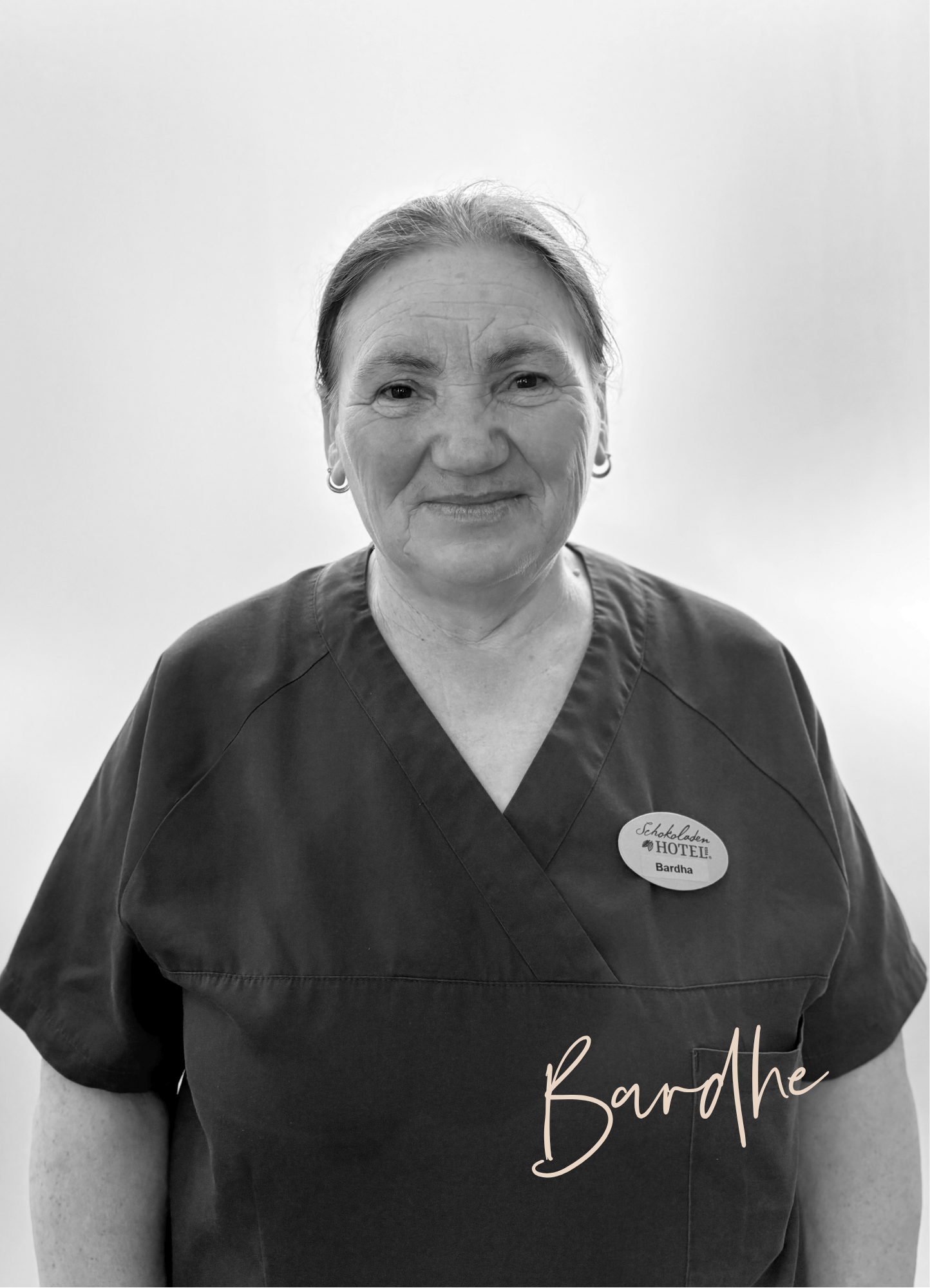 Eine Frau lächelt in die Kamera; sie trägt ein Namensschild.