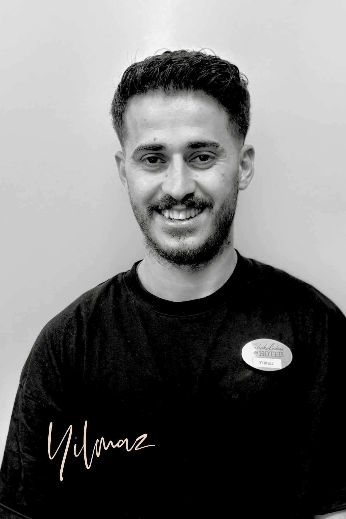 Yilmaz, unser Azubi aus dem Serviceteam. Er lächelt freundlich in die Kamera.