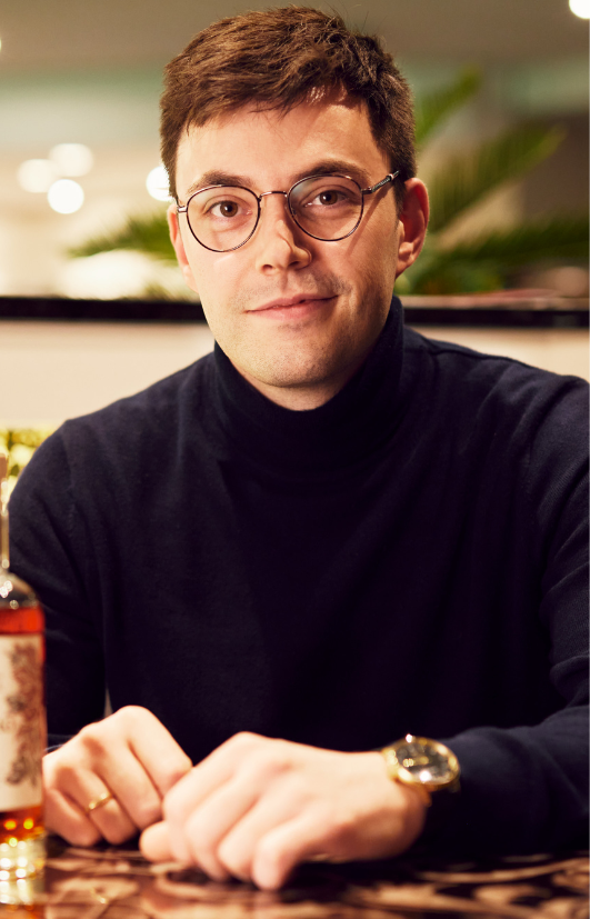 Ein Mann mit Brille und Uhr sitzt an einem Tisch