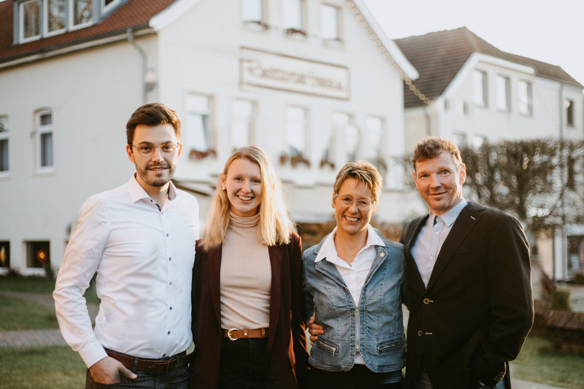 Eine Gruppe von Menschen posiert vor einem Gebäude für ein Foto.