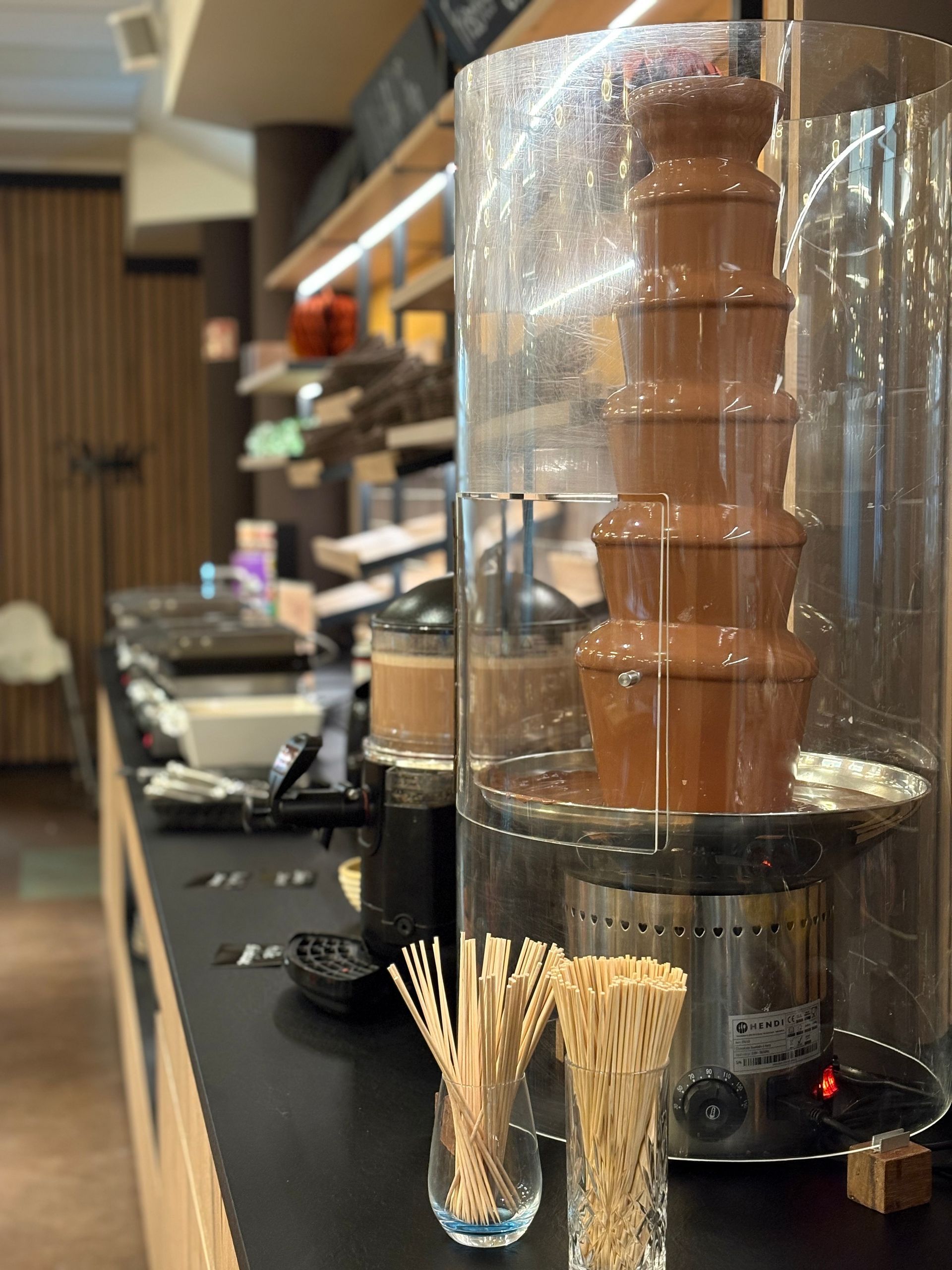 Ein Stapel goldbrauner Waffeln, mit Puderzucker bestäubt, auf einem weißen Teller im Schokoladenhotel.