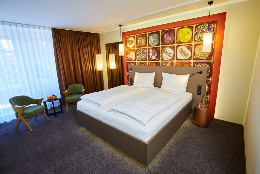 Ein Hotelzimmer mit einem großen Bett und Stühlen