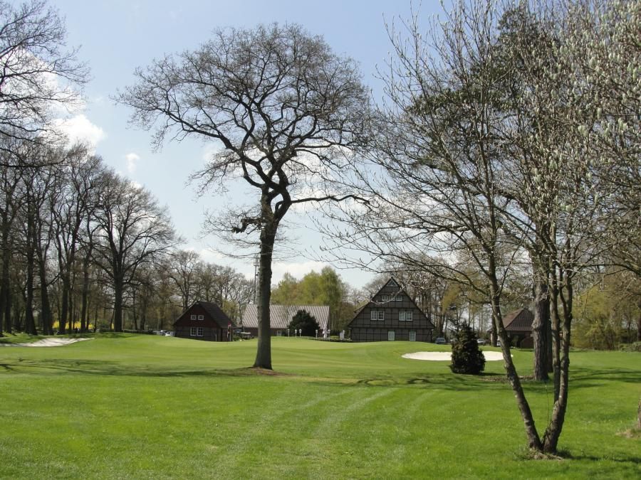 Golfplatz Hatten mit Bäumen und Häusern im Hintergrund