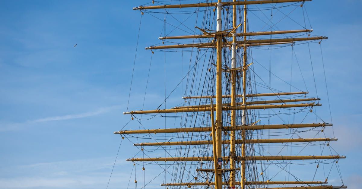 Die Masten eines Segelschiffes mit blauem Himmel im Hintergrund.
