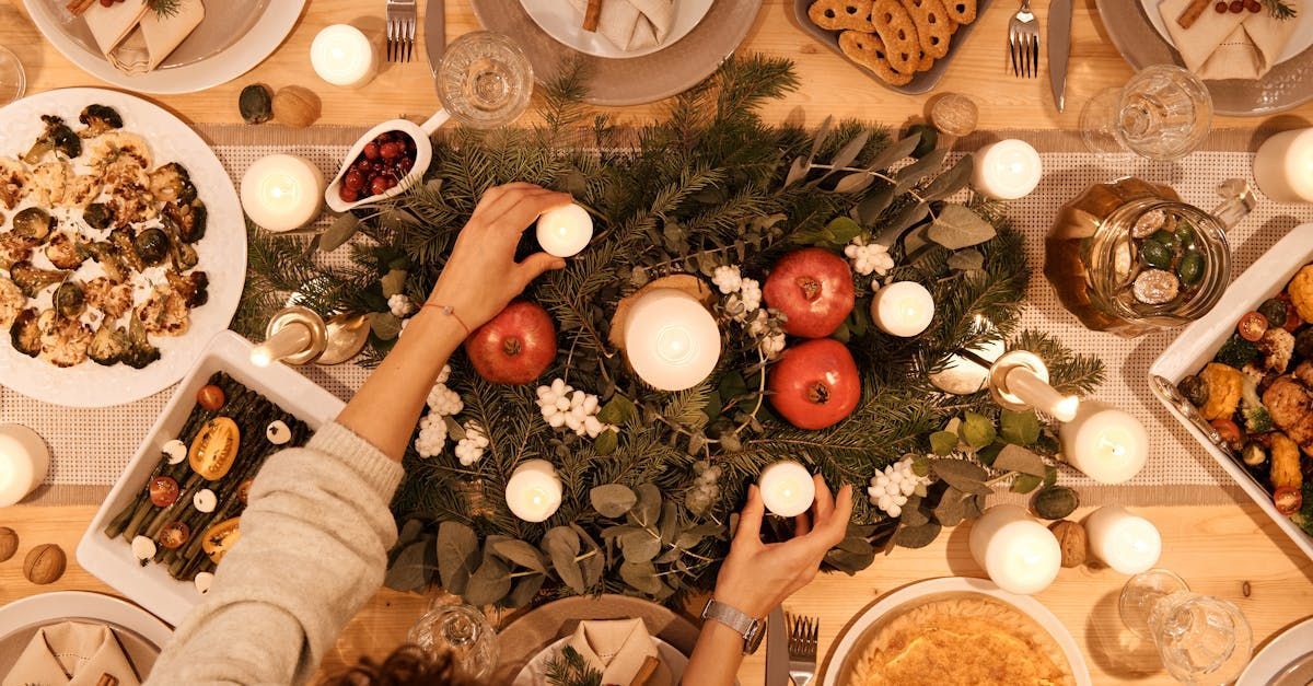 Eine Frau schmückt einen Weihnachtskranz mit Äpfeln und Kerzen.