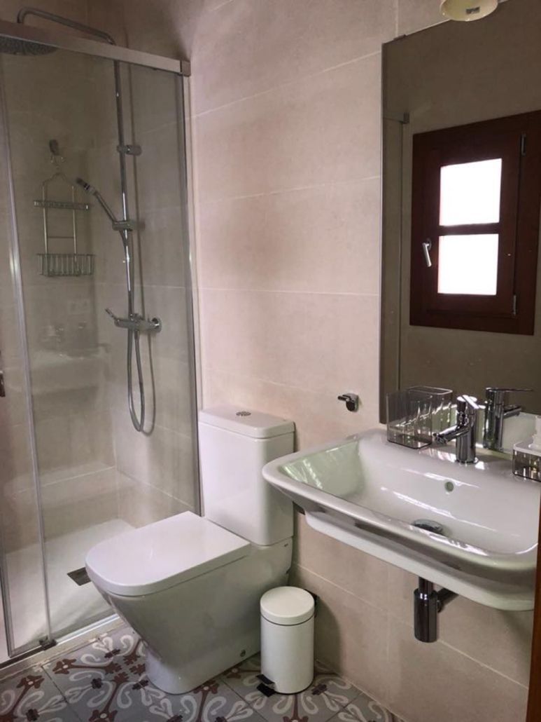 Un baño con inodoro, lavabo y ducha.