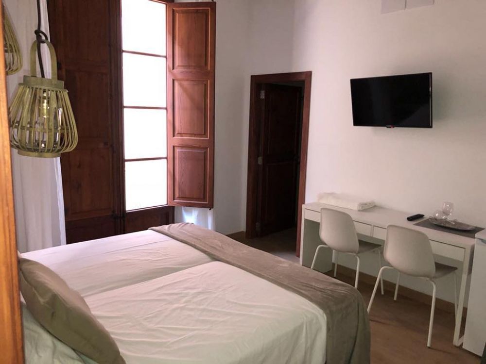 Un dormitorio con dos camas, un escritorio y un televisor de pantalla plana.