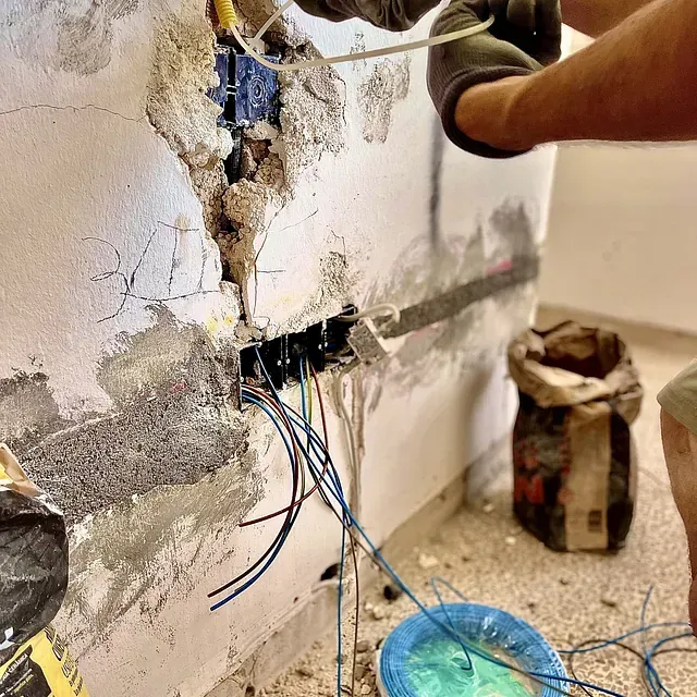 Una persona está trabajando en una pared que tiene un agujero.