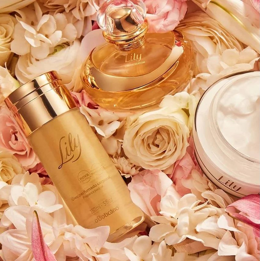 Perfume, loción y crema de lirio rodeado de flores rosas y blancas.
