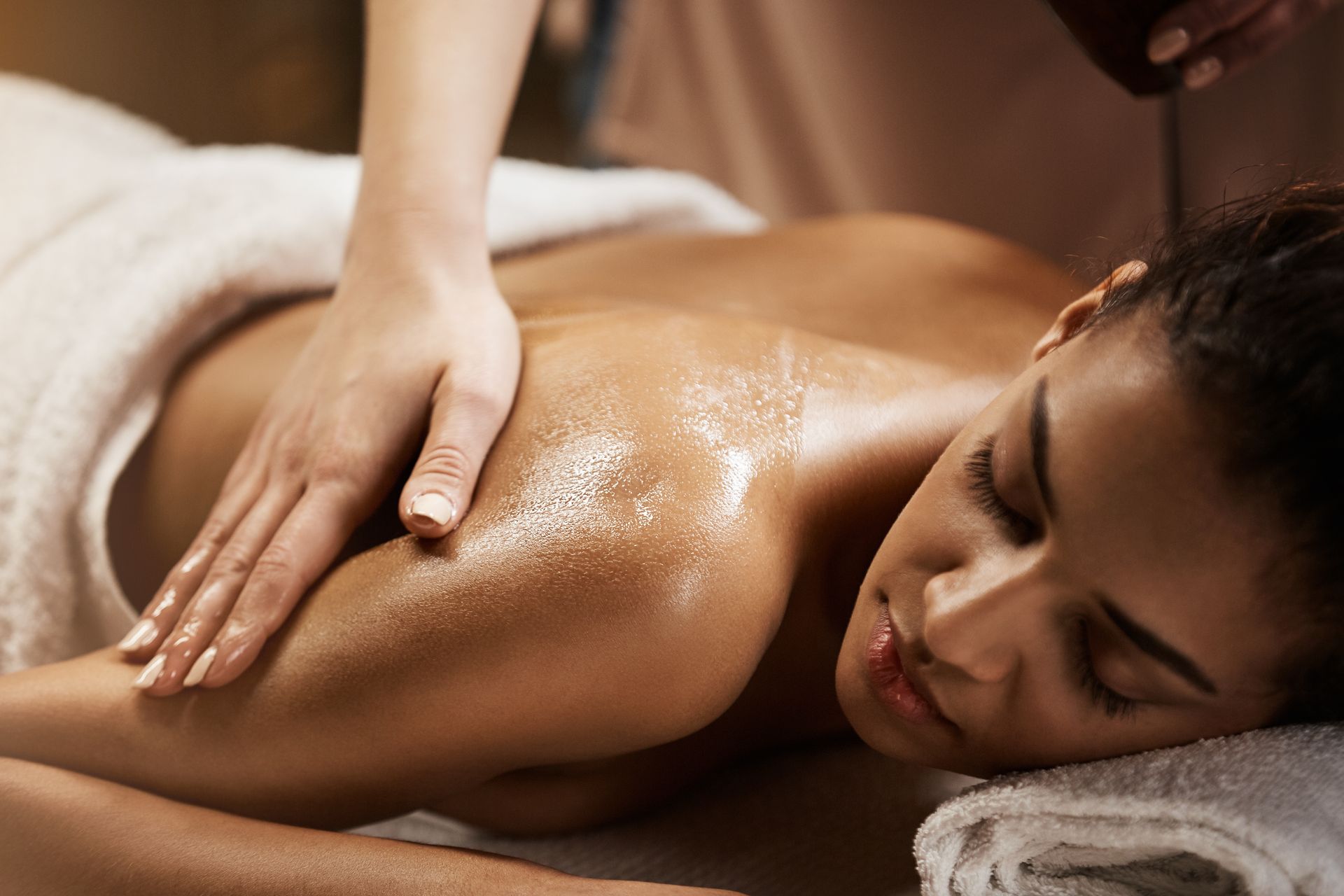 Personne recevant un massage relaxant du dos sur une table de spa