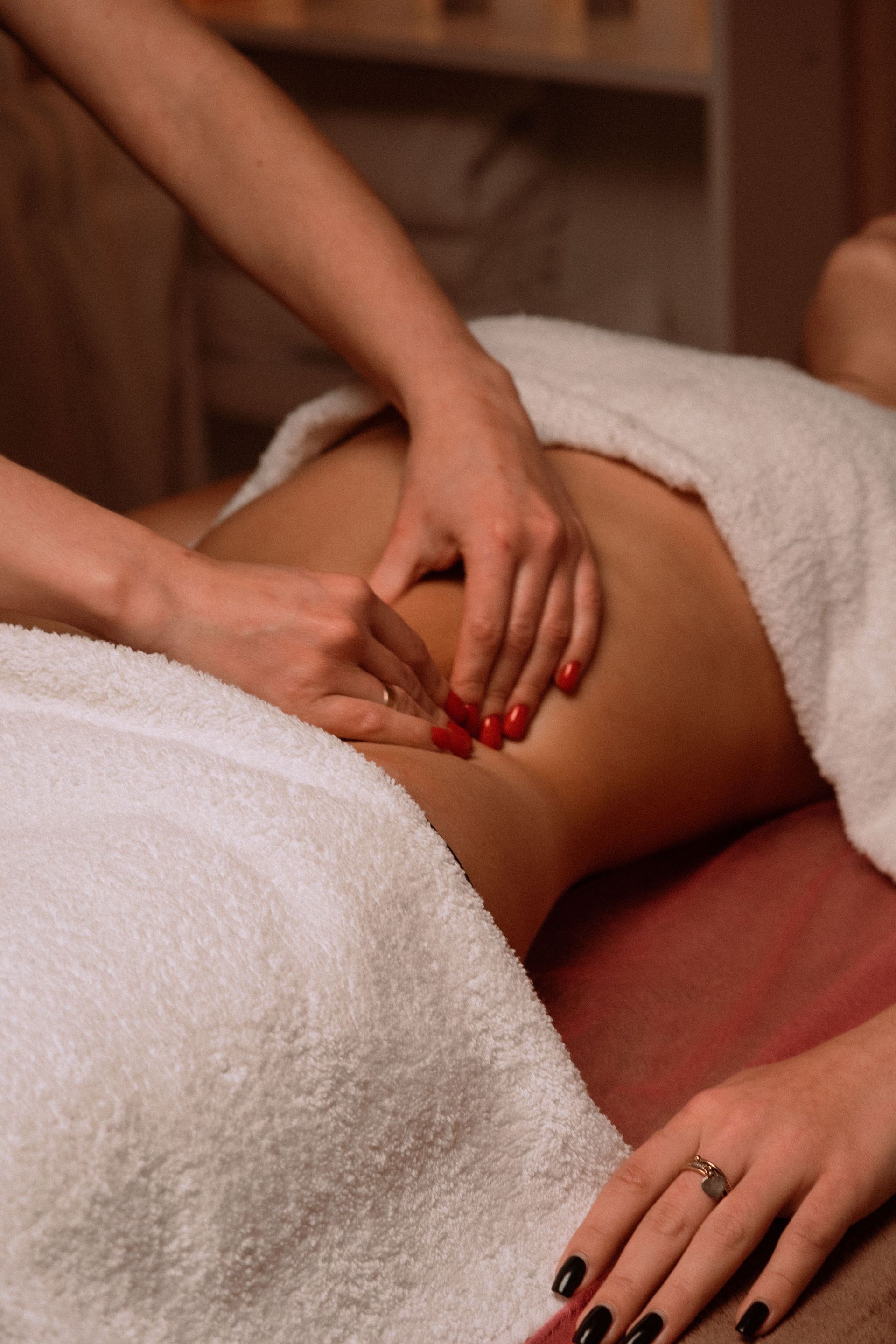Personne recevant un massage du dos avec un appareil portatif sur une table de traitement