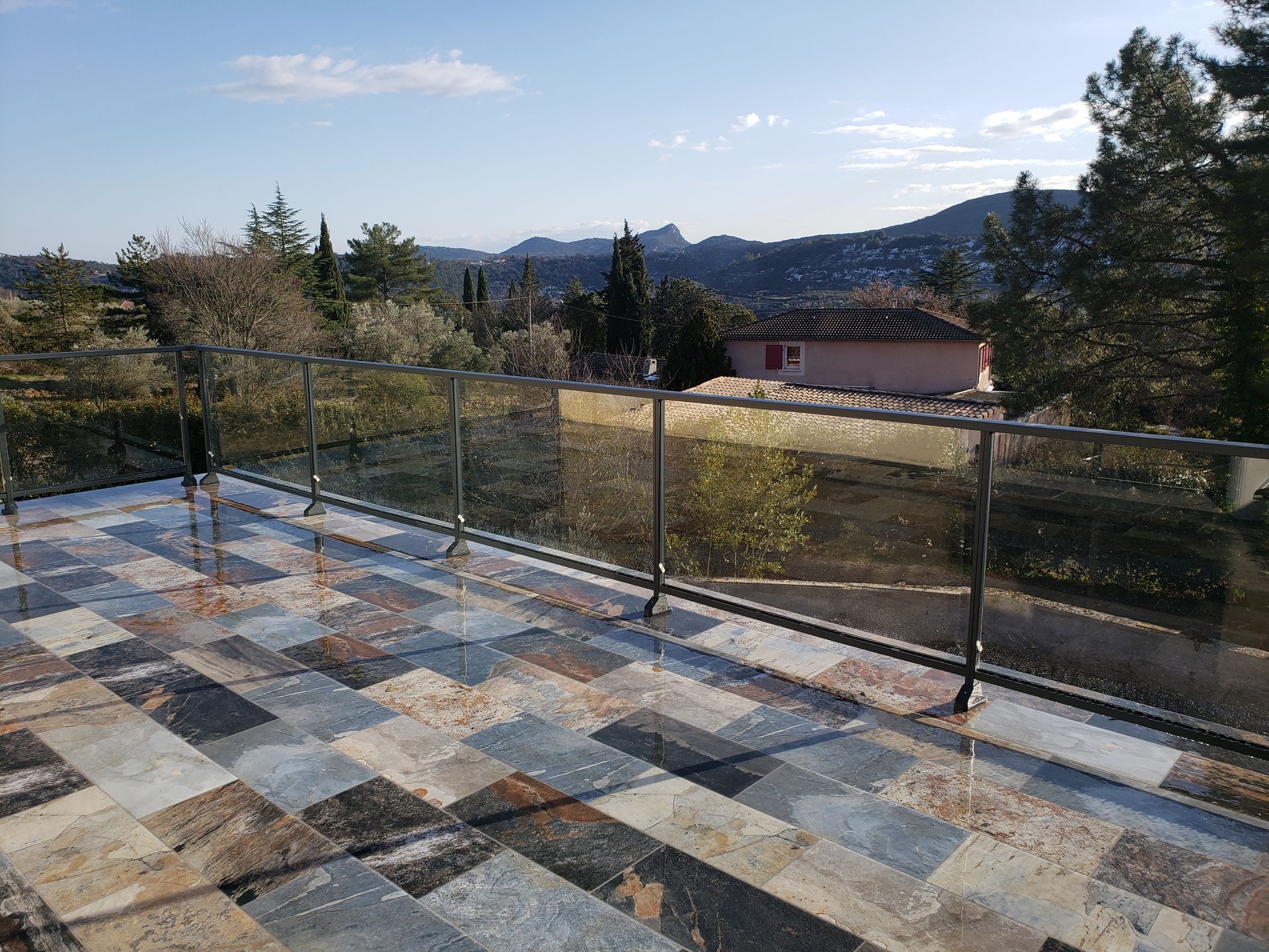 Garde-corps en fer noir et en vitre transparente sur terrasse en marbre