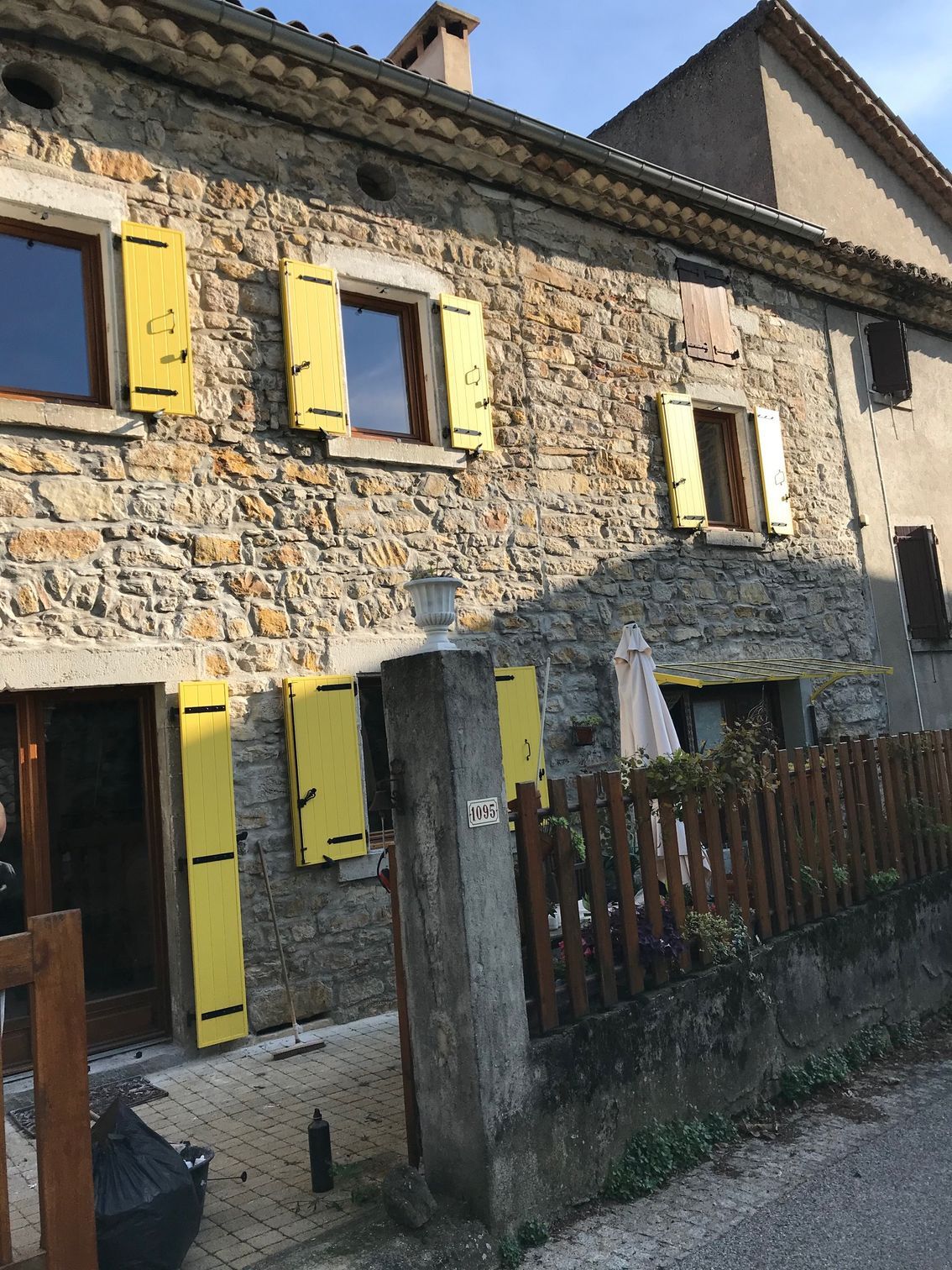 Volets battants PVC jaunes sur maison en pierre
