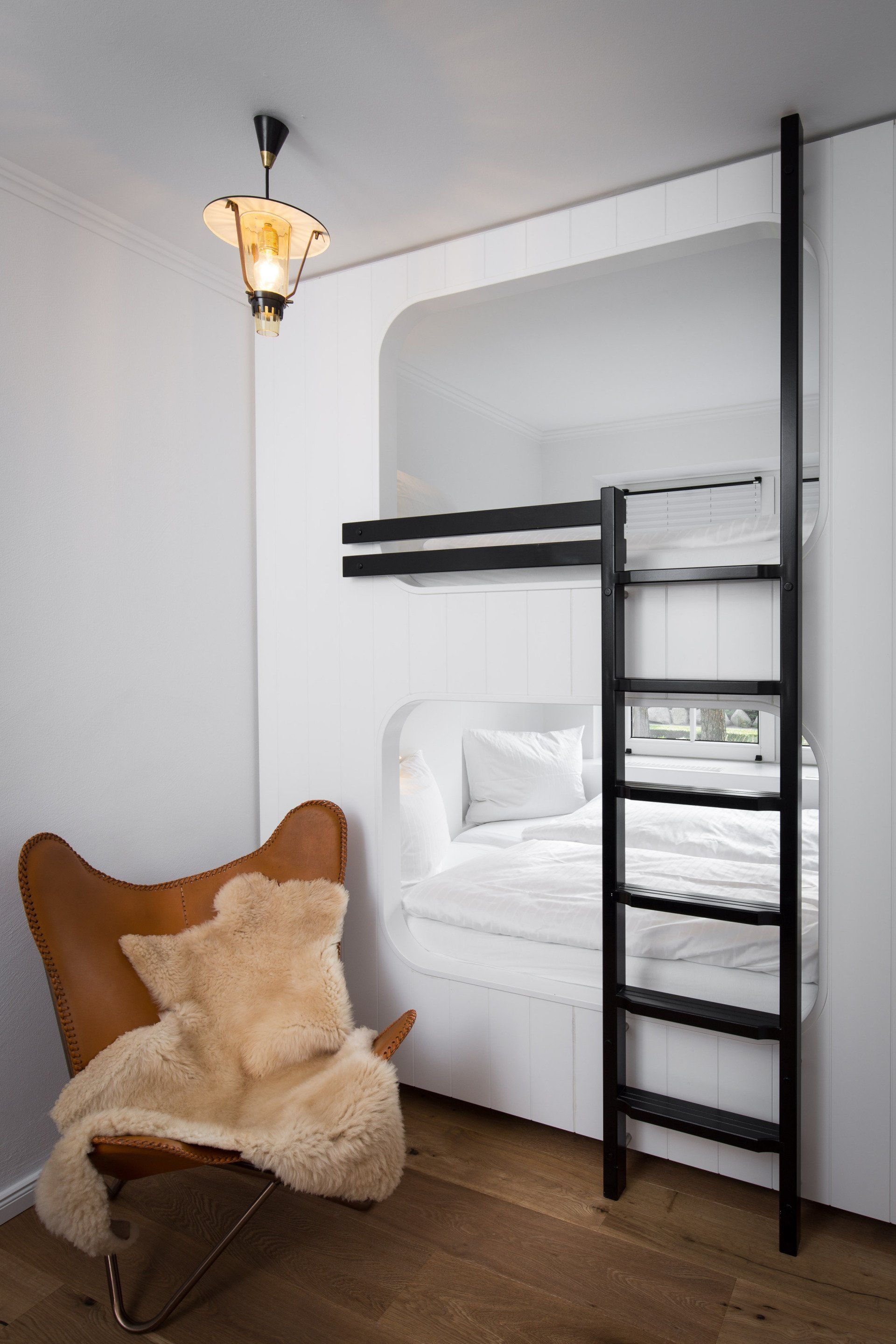 Ein Etagenbett mit einer Leiter und einem Stuhl in einem Zimmer.