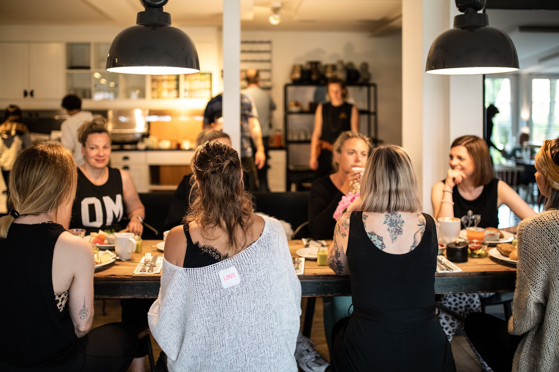 Eine Gruppe von Frauen sitzt während des Yogaurlaubs an einem Tisch und isst.