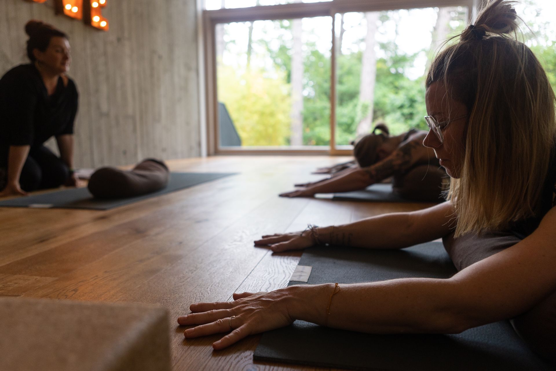 Eine Gruppe von Frauen macht in einem Raum Yoga.
