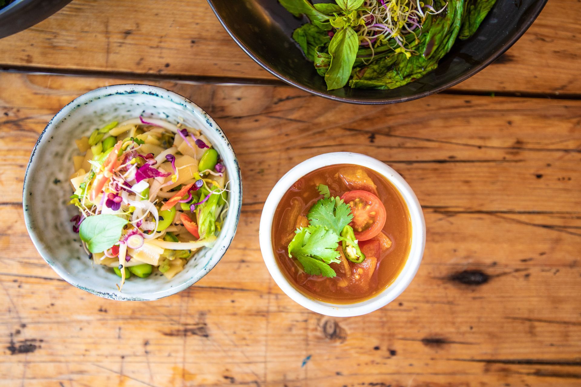 Auf einem Holztisch stehen zwei Schüsseln mit Essen.