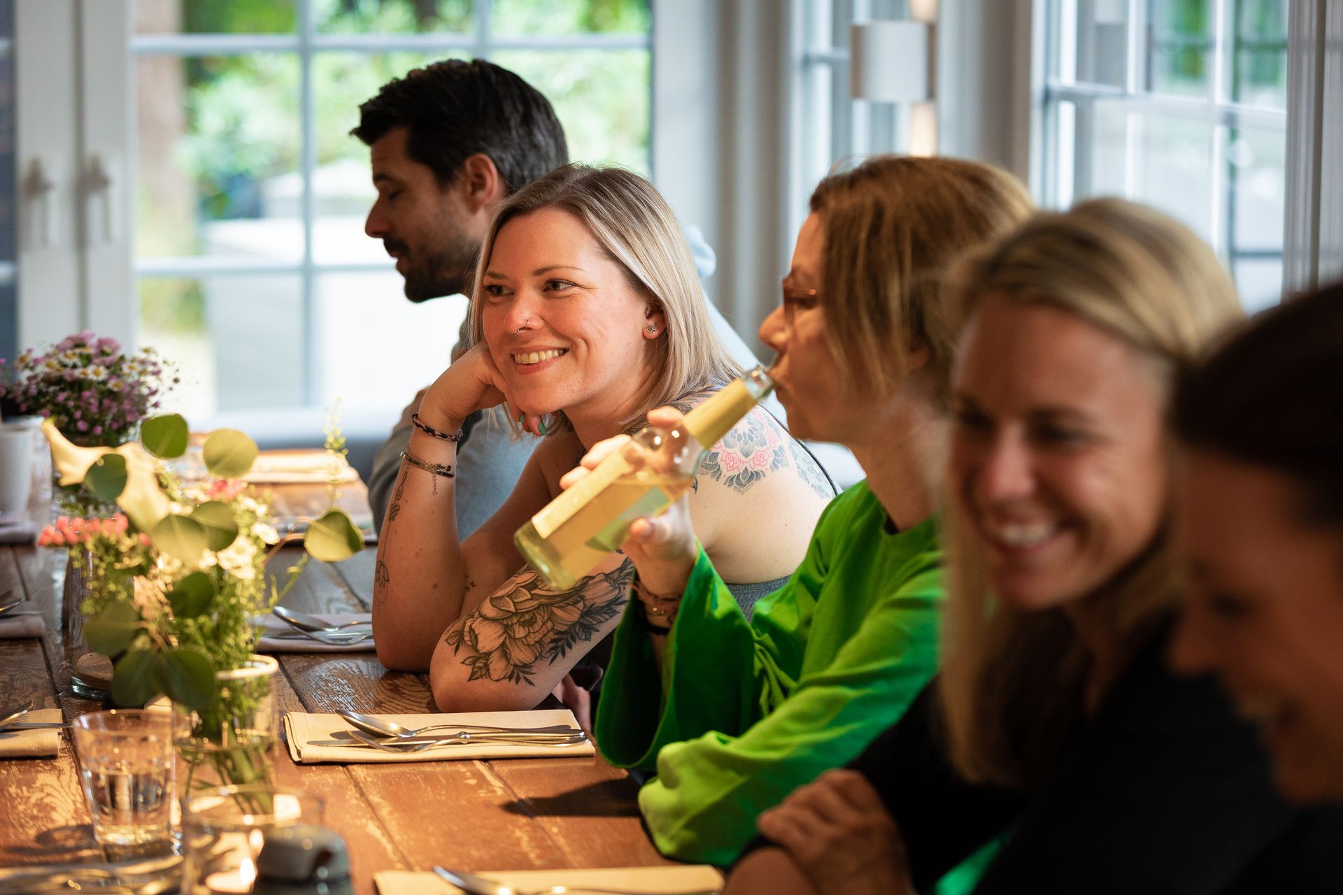 Eine Gruppe Leute sitzt an einem Tisch und trinkt Wein.