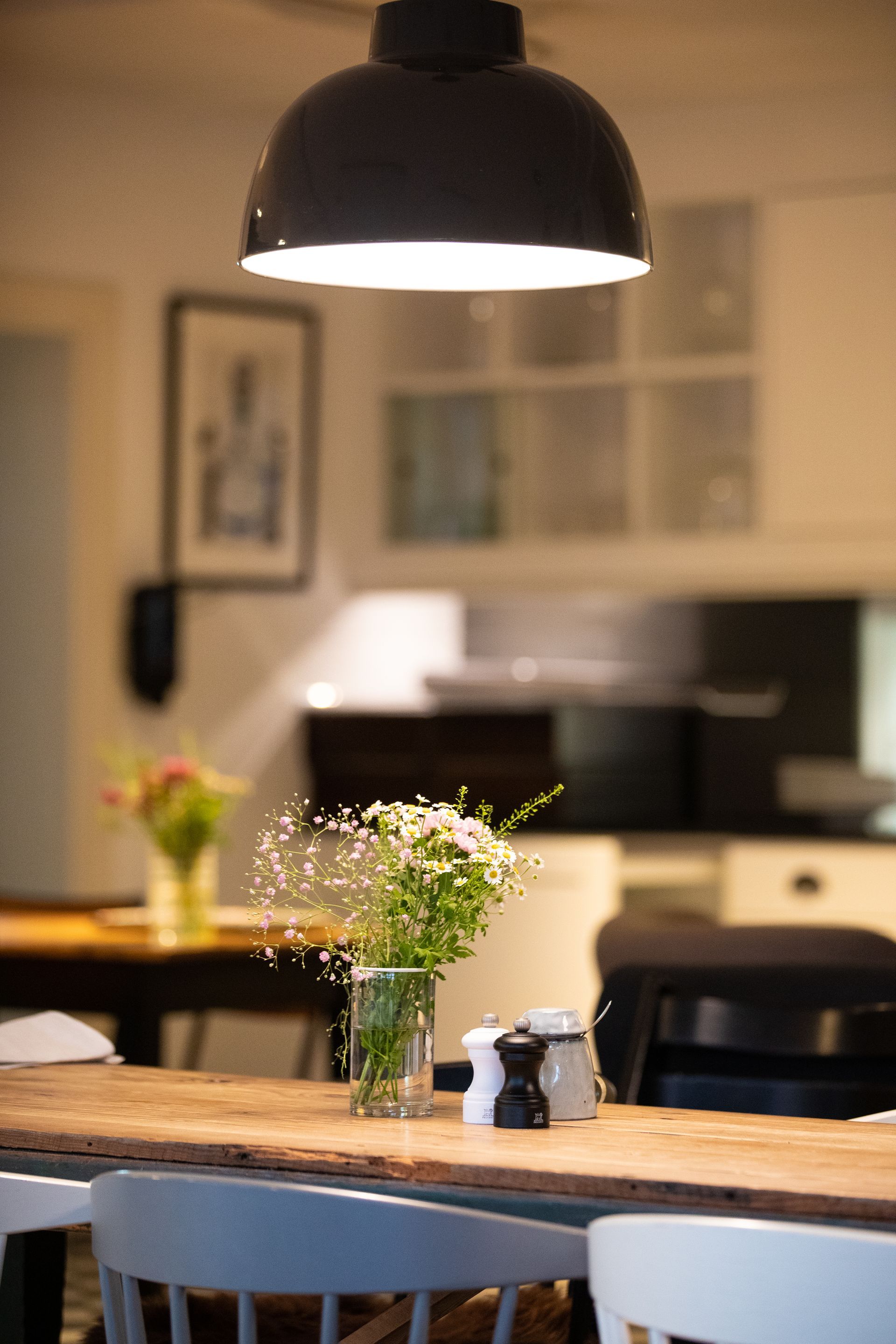 Ein Tisch mit einer Blumenvase darauf in einer Küche.