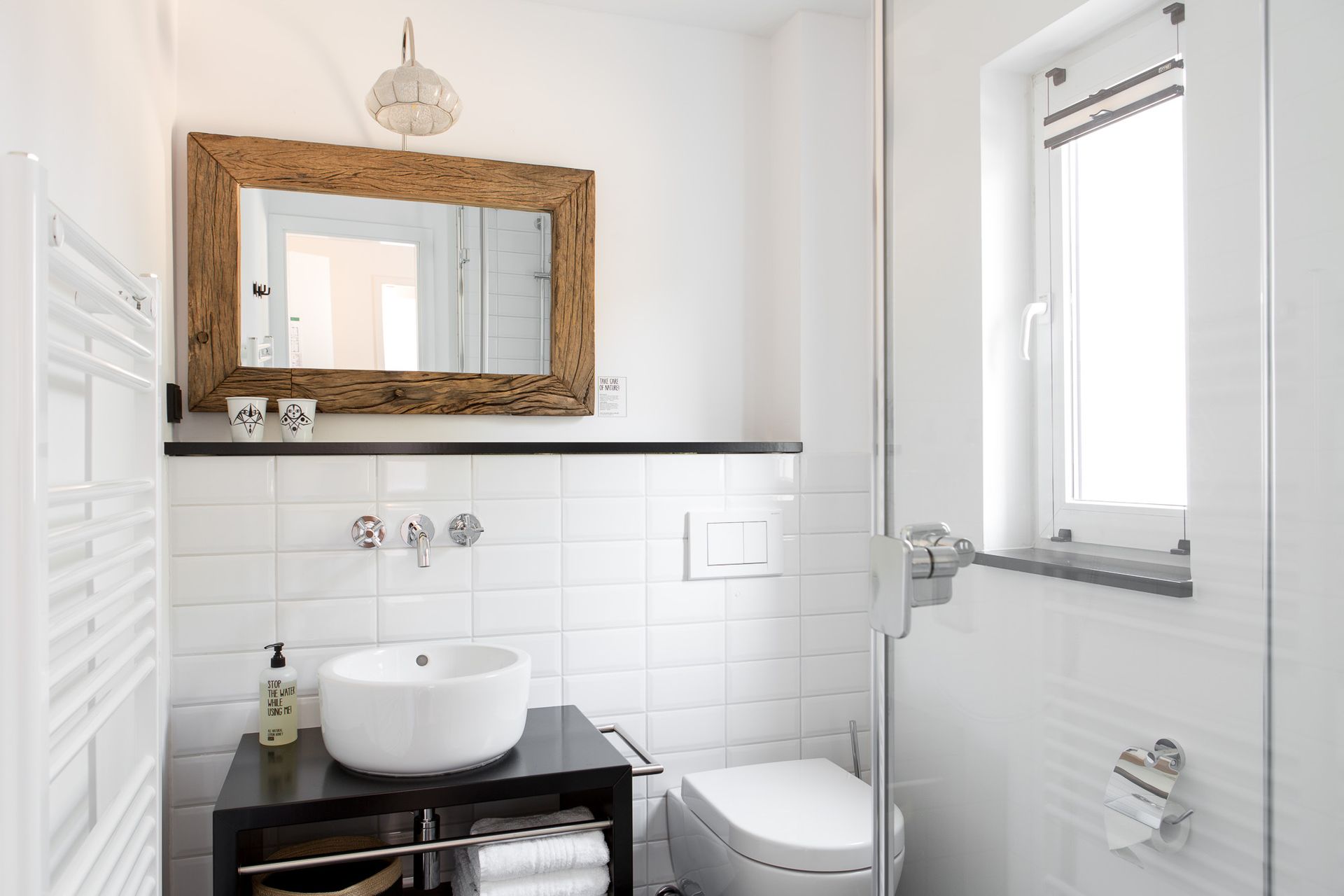 Ein Badezimmer mit Waschbecken, Toilette, Spiegel und Fenster.