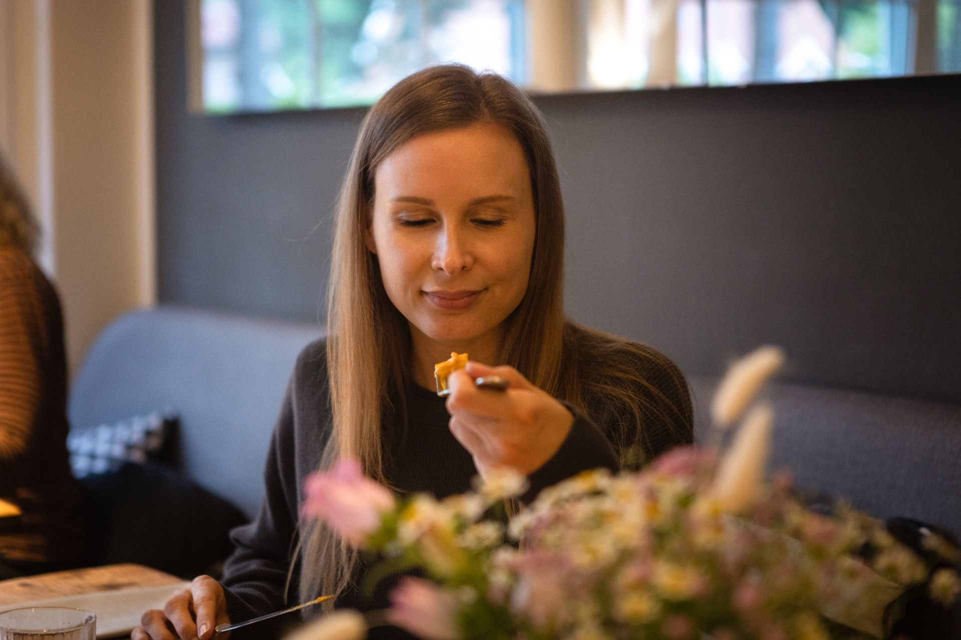 Eine Frau sitzt in einem Restaurant an einem Tisch und isst.