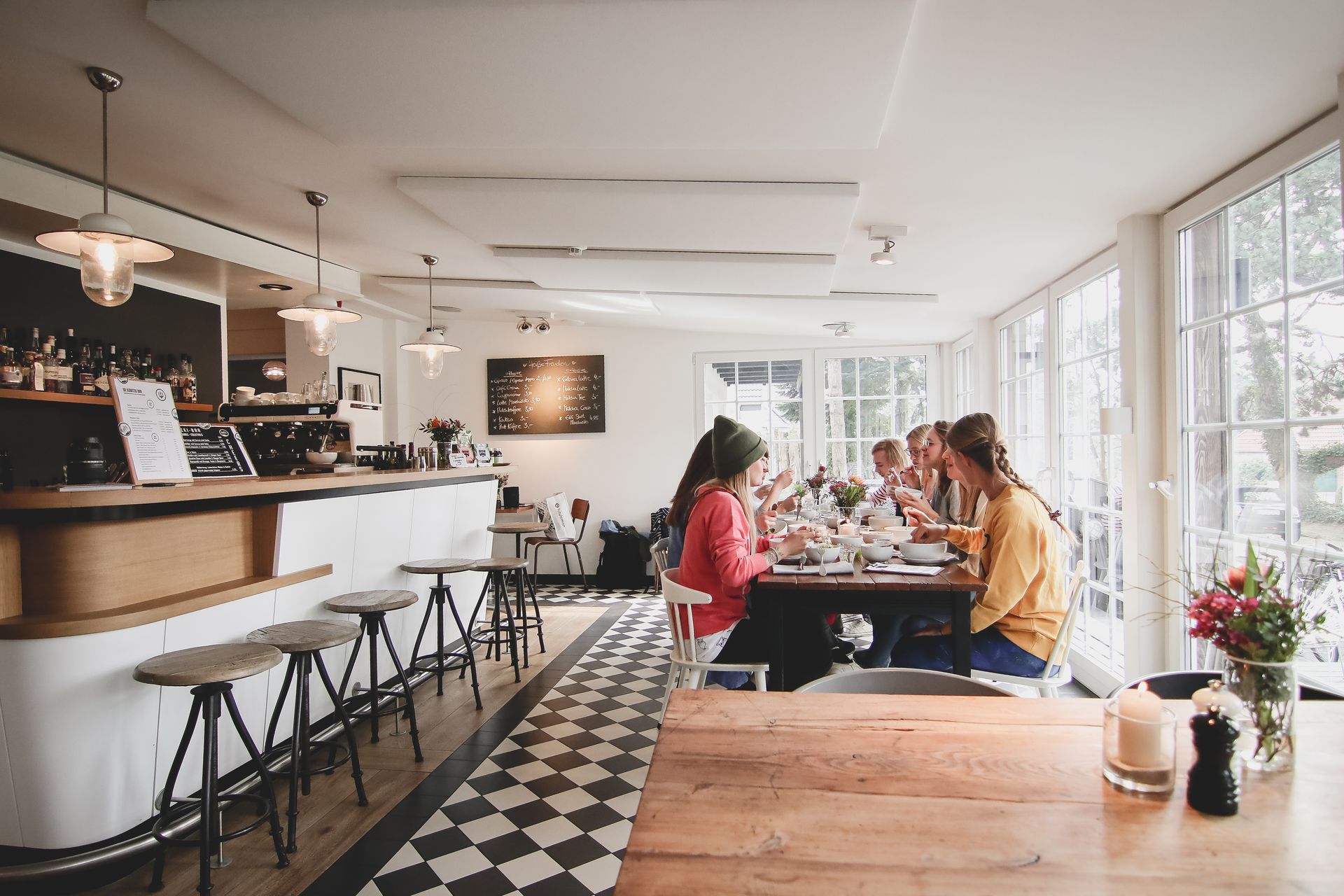 Eine Gruppe von Leuten, die Yogaurlaub machen, sitzt an Tischen in einem Restaurant.