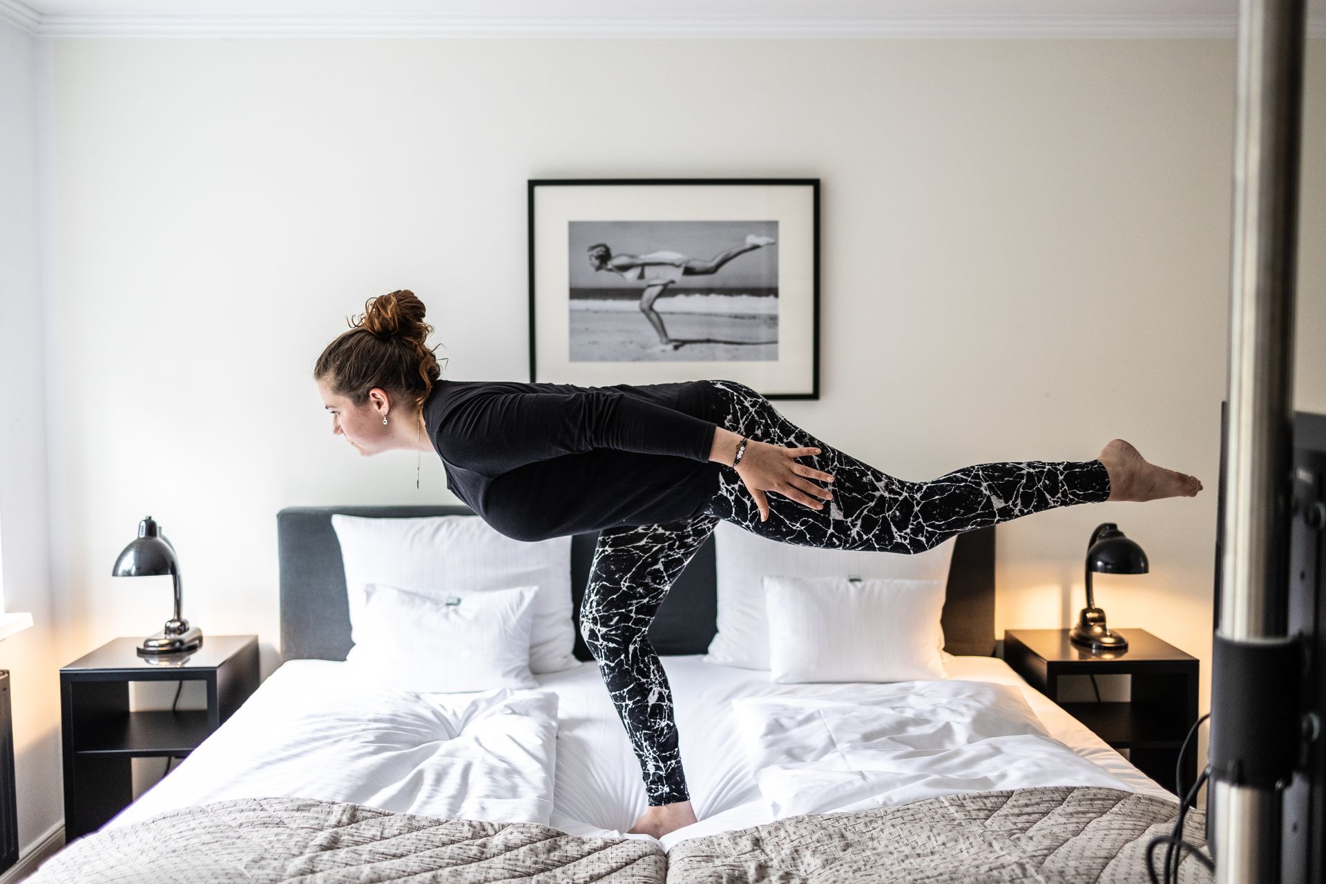 Yogapose auf einem Hotelbett