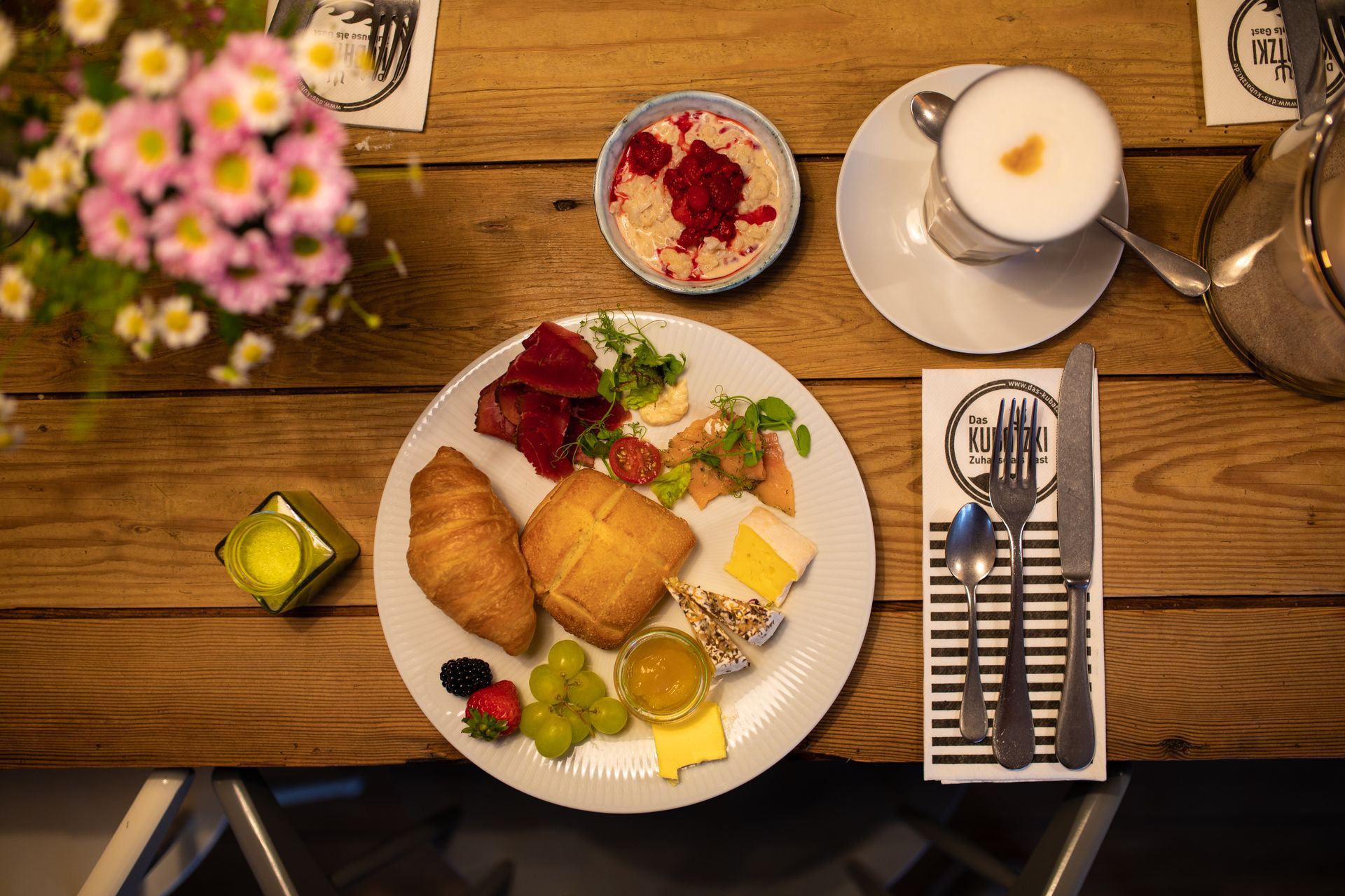 Ein Holztisch mit einem Teller mit Essen und einer Tasse Kaffee.