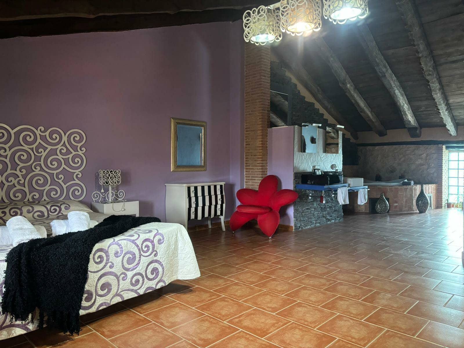 Un dormitorio con una cama, una silla y un espejo.