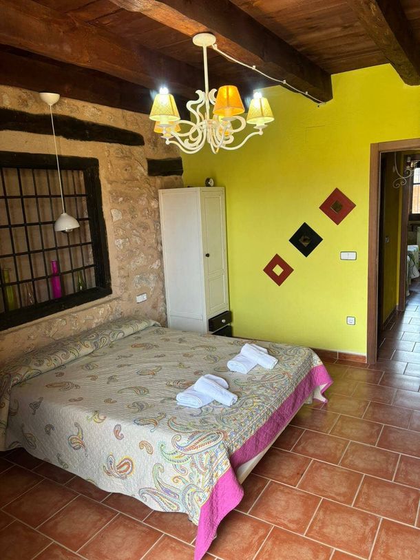 Un dormitorio con una cama grande y una lámpara de araña colgando del techo.